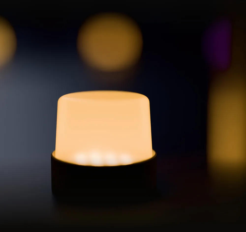 A shroud glowing amber like a candle on a dark floor, with other shrouds out of focus behind it, one of them purple.